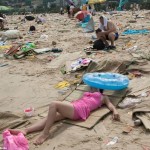 ชมภาพ ชาวจีนนับแสนนอนอาบแดด ท่ามกลางกองขยะบน ชายหาด อย่างไม่แยแส